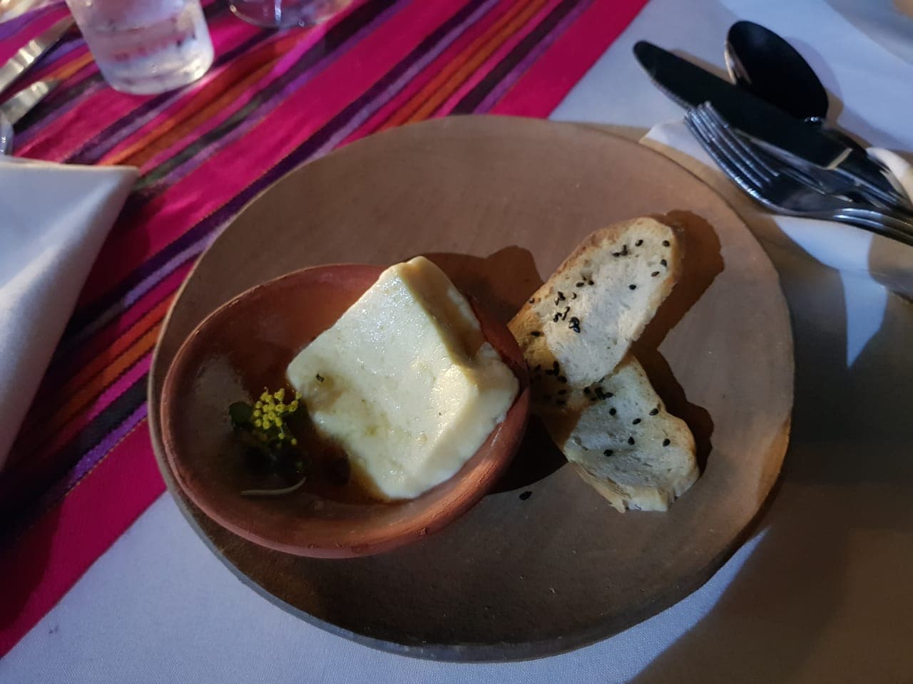 Queso de prensa con miel de palo e infusión de lavanda acompañado de pan campesino y quelites.